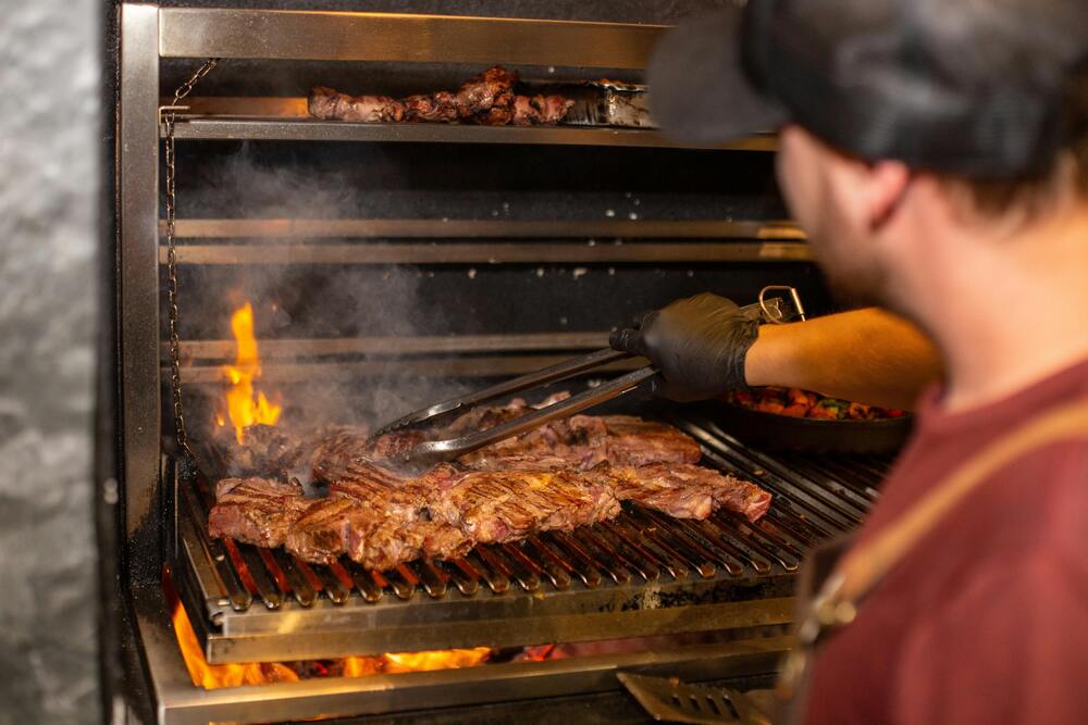 Steaks auf einem Holzkohlegrill grillen. Grillen im Freien